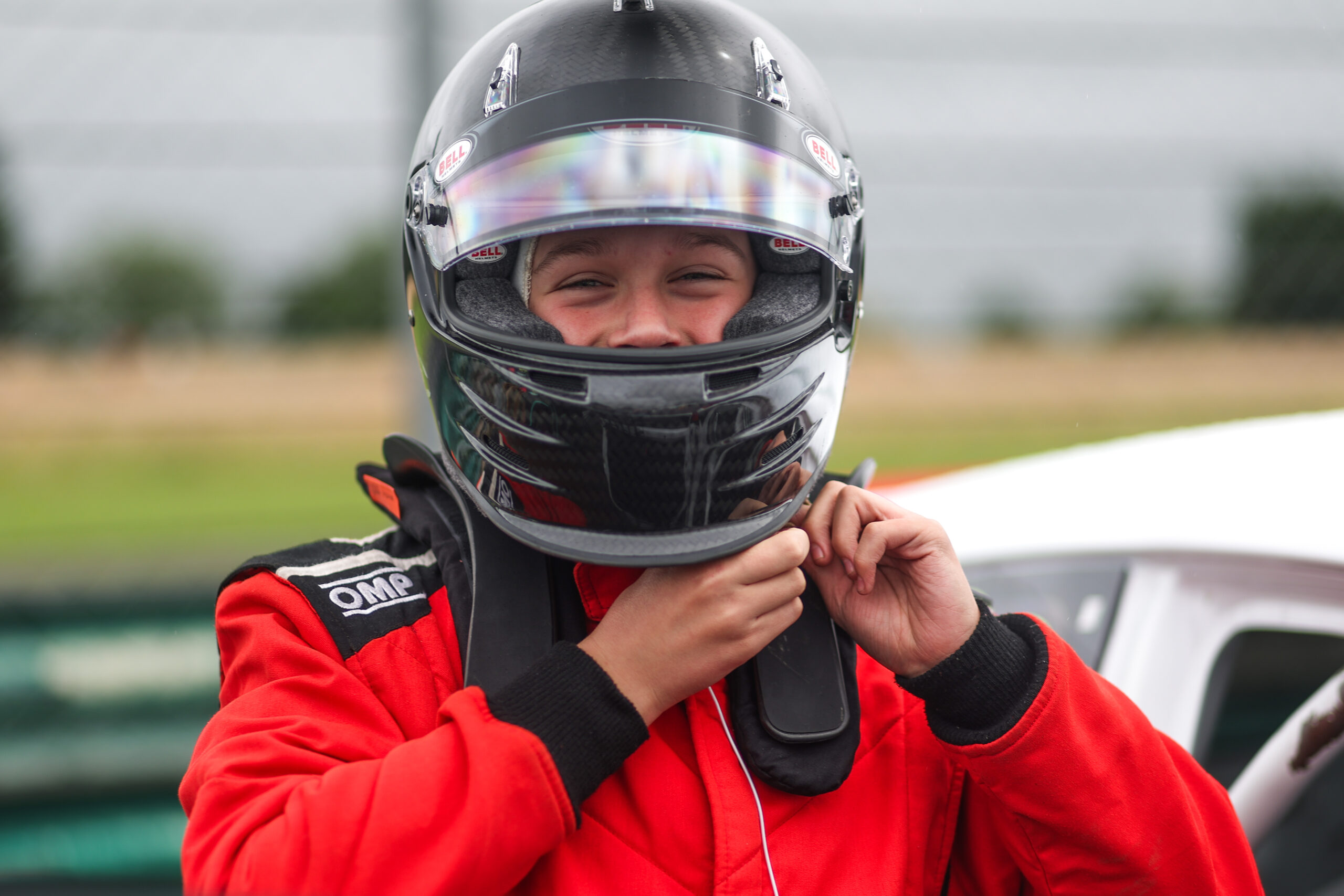 Harry fastening helmet in race suit